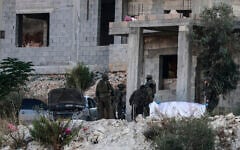 Israeli soldiers remove the body of a Palestinian killed in an air strike from a house under construction, on the western outskirts of the northern city of Jenin, in the West Bank on August 28, 2026. (Jaafar ASHTIYEH/AFP)