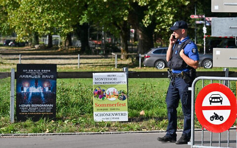Police officers secure the area next to a poster advertising a rave where a shooting occurred, in Aarau, northern Switzerland, on 30 August 2026. (Harold Cunningham/AFP)