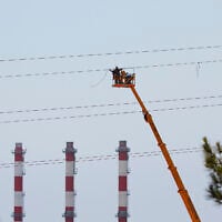 Electricity workers work to fix a power cable at Cyprus's main power station in Mari, Cyprus, July 12, 2011. (AP Photo/Petros Karadjias)