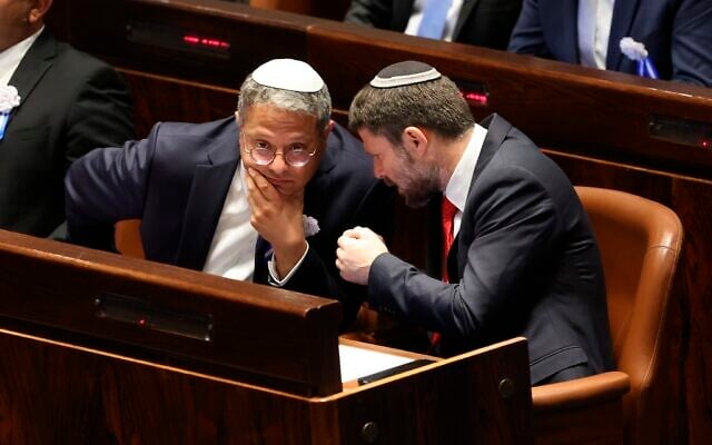 Israeli right wing Knesset member Itamar Ben Gvir, left, and Bezalel Smotrich, right, talk with each other during the swearing-in ceremony for Israeli lawmakers at the Knesset, Israel’s parliament, in Jerusalem, November 15, 2022. (Abir Sultan/Pool Photo via AP)