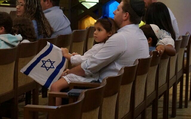 A family with Israel flags attends Shabbat services at Temple Beth Sholom in Miami Beach, Fla., on October 13, 2023. (AP Photo/Giovanna Dell’Orto)