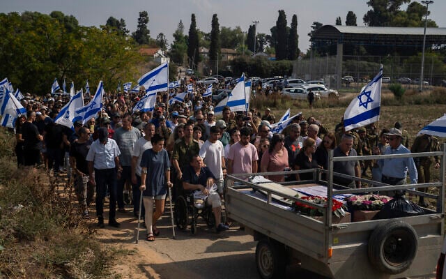 Avida Bachar who came to the funeral on the wheelchair, lost a leg the day of the attacks, attends the funeral with other family members and friends, of his wife Dana and his son Carmel, at Gan Shlomo cemetery, central Israel, October 24, 2023. (AP Photo/Petros Giannakouris) Avida Bachar who came to the funeral on the wheelchair, lost a leg the day of the attacks, attends the funeral with other family members and friends, of his wife Dana and his son Carmel, at Gan Shlomo cemetery, central Israel, October 24, 2023. (AP Photo/Petros Giannakouris)