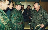 Bosnian Serb General Ratko Mladic, right, talks on the phone next to Russian Army General Vladimir Zurbenko, center, during the visit of a Russian Army delegation to the Bosnian town of Banja Luka in October 1995. (AP Photo/Radivoje Pavicic)