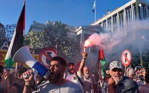 A protester holds a flare as others chant pro-Palestinian slogans outside Greece’s Foreign Ministry after Israel’s navy intercepted an activists flotilla in waters off of Cyprus, in Athens on May 18, 2026. (AP Photo/Petros Giannakouris)