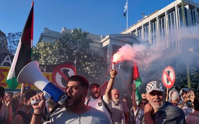 A protester holds a flare as others chant pro-Palestinian slogans outside Greece’s Foreign Ministry after Israel’s navy intercepted an activists flotilla in waters off of Cyprus, in Athens on May 18, 2026. (AP Photo/Petros Giannakouris)