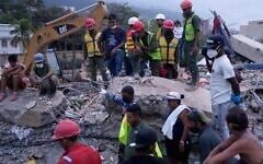 Rescue workers and relatives search for loved ones at a building collapsed by earthquakes in La Guaira, Venezuela, July 21, 2026. (AP Photo/Ariana Cubillos)