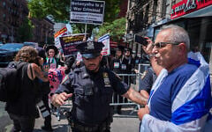 A pro-Israeli protester is held back by an NYPD officer during a rally in opposition to New York City Mayor Zohran Mamdani in New York, July 26, 2026. (AP/Ryan Murphy)