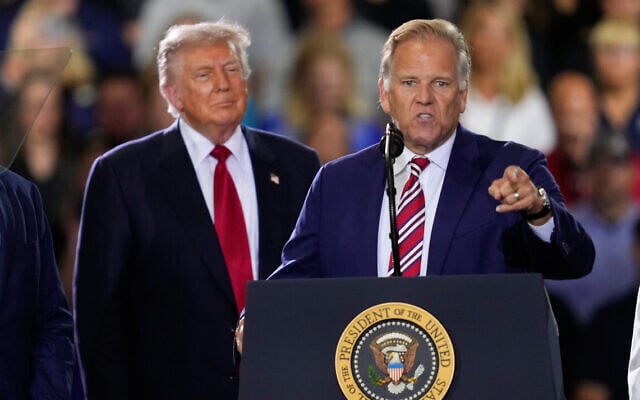 Republican Senate candidate Mike Rogers speaks as US President Donald Trump listens, at an event at the General Motors Proving Ground July 27, 2026, in Milford, Michigan. (AP Photo/Paul Sancya)
