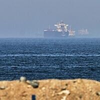 Cargo ships are seen at sea near the Strait of Hormuz, as viewed from a rocky shoreline near Khor Fakkan, United Arab Emirates, May 1, 2026. (AP Photo/Fatima Shbair)