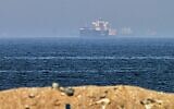 Cargo ships are seen at sea near the Strait of Hormuz, as viewed from a rocky shoreline near Khor Fakkan, United Arab Emirates, May 1, 2026. (AP/Fatima Shbair)