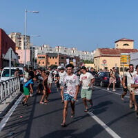 Migrants run from Spanish police officers after crossing from Morocco into the Spanish enclave of Ceuta, July 31, 2026. (AP Photo/Antonio Sempere)