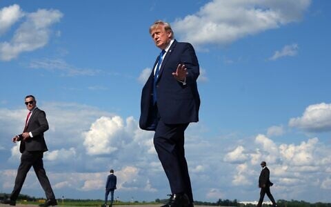 US President Donald Trump waves as he walks from Air Force One at Morristown Municipal Airport in Morristown, New Jersey, July 31, 2026, from Camp David, the presidential retreat. (AP Photo/Jacquelyn Martin)