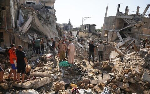 Palestinians inspect destroyed buildings at the scene of an Israeli airstrike, at al-Maghazi refugee camp, central Gaza Strip, August 1, 2026. (AP/Abdel Kareem Hana)