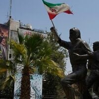 A statue of Palestinians stands with Iranian flag as a banner shows newly elected Hamas leader Khalil al-Hayya, center, alongside the late leaders Ismail Haniyeh, right, and Yahya Sinwar, with writing in Hebrew reads: 'From Sinwar’s generation, the new leader on the ground,' and in Arabic: 'Khalil al-Hayya, the occupiers’ nightmare” at Palestine Square in downtown Tehran, Iran, August 1, 2026. (AP Photo/Vahid Salemi)