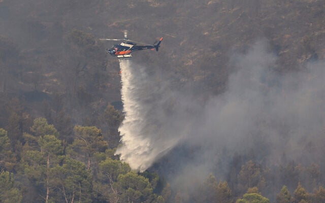 A firefighting helicopter releases water over a wildfire near Correns, southeastern France, August 1, 2026. (Clement Mahoudeau/Pool Photo via AP)