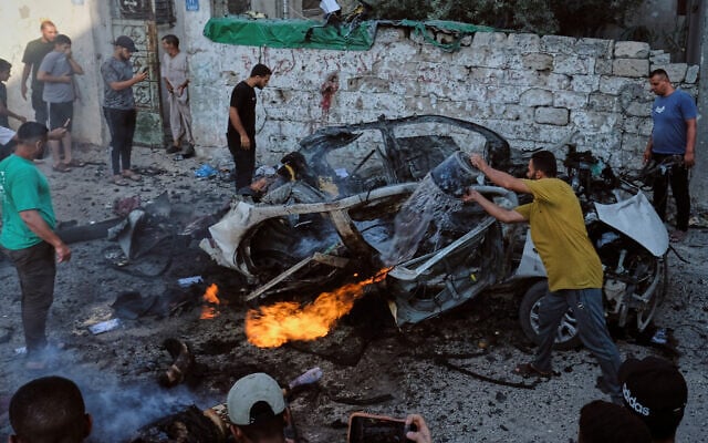 Palestinians try to extinguish a burning car after an Israeli military strike in Gaza City, August 2, 2026. (AP/Jehad Alshrafi)