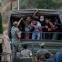 Migrants who crossed into Spain are escorted by Spanish soldiers towards the Spanish-Moroccan border for their return to Morocco from the Spanish enclave of Ceuta, August 2, 2026. (AP Photo/Antonio Sempere)