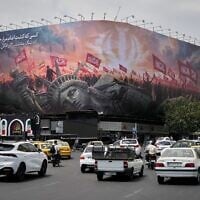 A billboard depicting a fallen Statue of Liberty and crowds carrying Iranian and Shiite flags overlooks Revolution Square as traffic drives by in Tehran, Iran, August 3, 2026. (AP Photo/Vahid Salemi)