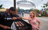 Rep. Debbie Wasserman Schultz, D-Florida, greets a man tending to a grill as she visits a National Night Out community event while campaigning for Florida’s 20th congressional district, in Plantation, Florida, August 4, 2026.