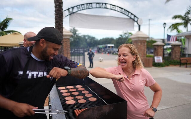 Rep. Debbie Wasserman Schultz, D-Florida, greets a man tending to a grill as she visits a National Night Out community event while campaigning for Florida’s 20th congressional district, in Plantation, Florida, August 4, 2026.