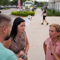 Rep. Debbie Wasserman Schultz, bottom right, talks with a pair of constituents who approached her to request help with a problem, at a National Night Out community event where she was campaigning for Florida’s 20th congressional district, August 4, 2026, in Plantation, Florida. (AP Photo/Rebecca Blackwell).