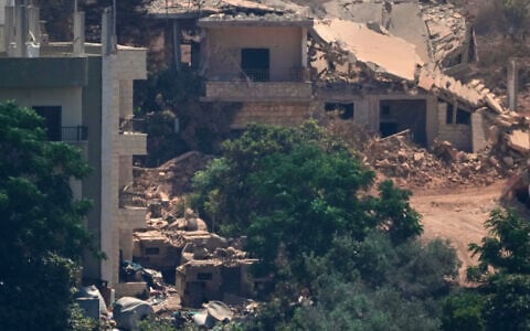 Israeli military vehicles, left, are seen stationed among homes in the village of Zawtar al-Sharqiyah, occupied by Israeli forces, is seen from the southern village of Zawtar al-Gharbieh, Lebanon, August 5, 2026. (AP Photo/Mohammed Zaatari)