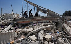 Illustrative: A Lebanese family take shade under damaged solar panels of their destroyed house in the village of Zawtar al-Gharbieh, south Lebanon, August 5, 2026. (AP Photo/Mohammed Zaatari)