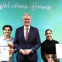 Fatemeh Pasandideh, left, and Atefeh Ramezanisadeh, former members of the Iranian women’s soccer team, stand with Australia’s Home Affairs Minister Tony Burke, after receiving their citizenship in Brisbane, Australia, August 5, 2026. (Department of Home Affairs via AP)
