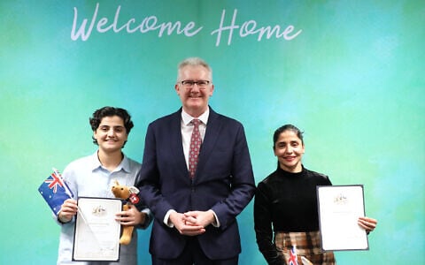 Fatemeh Pasandideh, left, and Atefeh Ramezanisadeh, former members of the Iranian women’s soccer team, stand with Australia’s Home Affairs Minister Tony Burke, after receiving their citizenship in Brisbane, Australia, August 5, 2026. (Department of Home Affairs via AP)