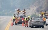 Emergency crews talk to the driver of a car at a closed section of Highway 97 south of Peachland, British Columbia, Canada, on August 8, 2026. (Gary Nylander/The Canadian Press via AP)