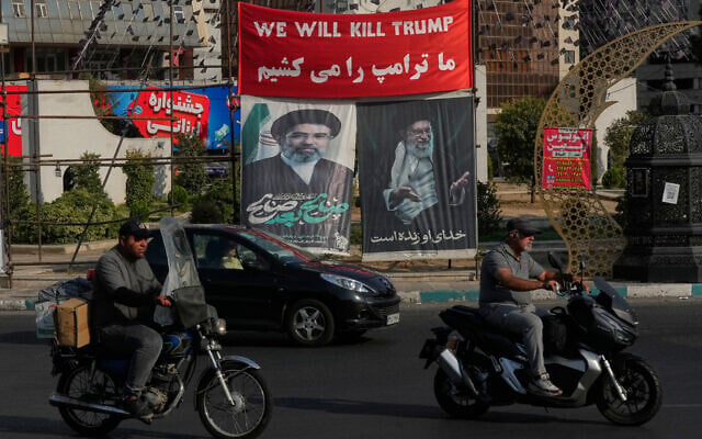 Vehicles drive past a banner reading in English and Farsi, 'We will kill Trump,' and banners showing portraits of the late Iranian supreme leader ayatollah Ali Khamenei, right, and his son Ayatollah Mojtaba Khamenei, in Tehran, Iran, August 10, 2026. (AP/Vahid Salemi)