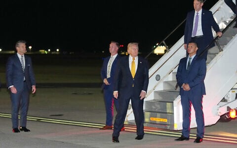 As Defense Secretary Pete Hegseth watches at left, US President Donald Trump walks from the legacy Air Force One to switch planes at US Air Force Base, RAF Mildenhall in Suffolk Eastern England, on his way back to Washington from the NATO summit in Ankara, Turkey, July 8, 2026. (AP Photo/Alex Brandon)