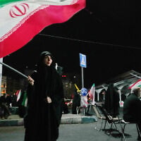 A woman waves an Iranian flag during a pro-government gathering at a square in Tehran, Iran, August 11, 2026. (AP Photo/Vahid Salemi)