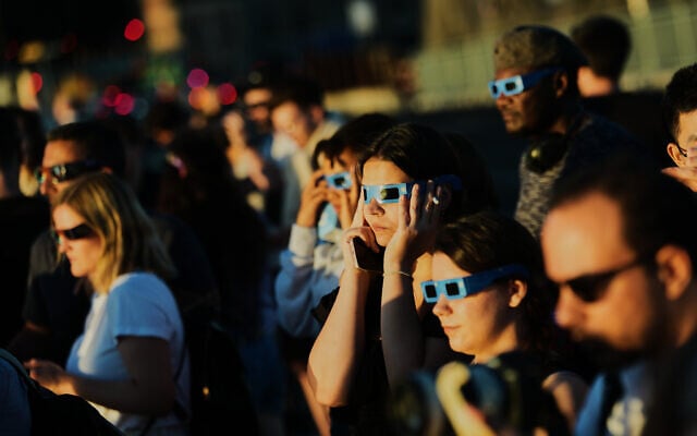 People use solar eclipse glasses to look up at the sun during a solar eclipse in Berlin, Germany, August 12, 2026. (AP Photo/Markus Schreiber)