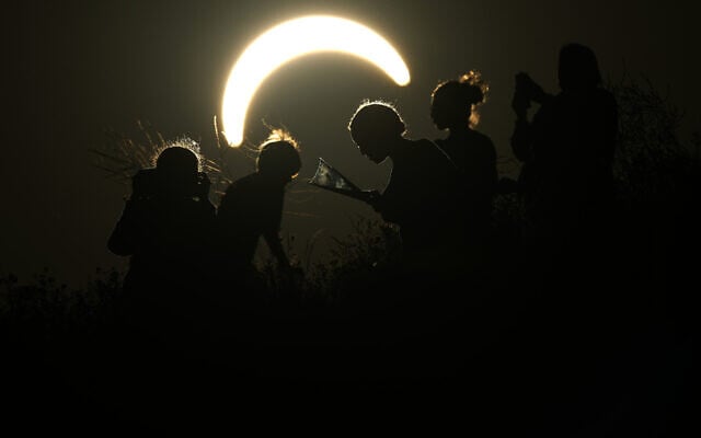 People observe a partial solar eclipse at Northala Fields in London, August 12, 2026. (AP Photo/Frank Augstein)