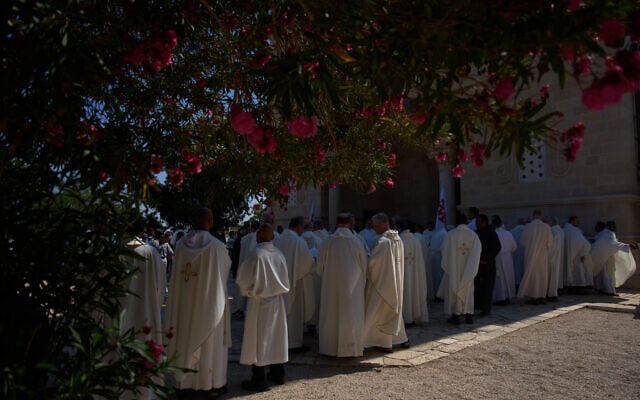 Priests gather at the garden of the Basilica of the Transfiguration on Mount Tabor, northern Israel, on August 6, 2026. (AP Photo/Ariel Schalit)