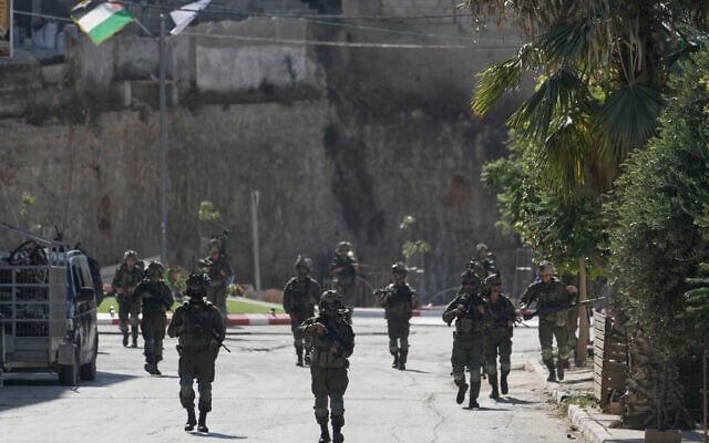 IDF soldiers patrol the streets of the West Bank village of Qusra, south of Nablus, August 13, 2026. (AP/Majdi Mohammed)