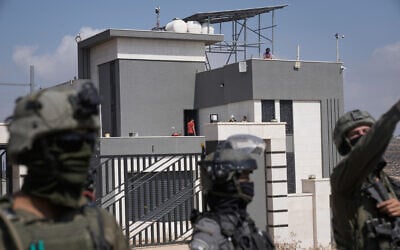 Israeli forces stand in front of the entrance of a Palestinian house besieged by Israeli settlers in the village of Qusra, south of Nablus, in the West Bank, on August 14, 2026. (AP Photo/Majdi Mohammed) Israeli forces stand in front of the entrance of a Palestinian house besieged by Israeli settlers in the village of Qusra, south of Nablus, in the West Bank, on August 14, 2026. (AP Photo/Majdi Mohammed)