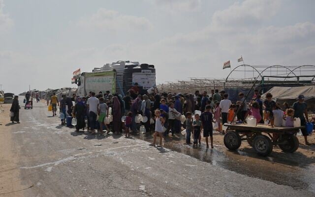 Displaced Palestinians gather to refill fresh water by a water supplier in Deir al-Balah, central Gaza Strip, Aug 14, 2026. (AP/Abdel Kareem Hana)