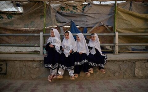 Four young girls dressed in matching outfits hold Taliban flags on the eve of the fifth anniversary of the US withdrawal and the start of Taliban rule in Kabul, Afghanistan, August 14, 2026. (AP Photo/Nava Jamshidi)
