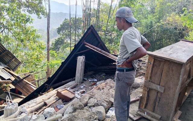 A man examines the damage to a building following an earthquake in East Manggarai, East Nusa Tenggara province, Indonesia, August 15, 2026. (AP Photo/Kurniawan)