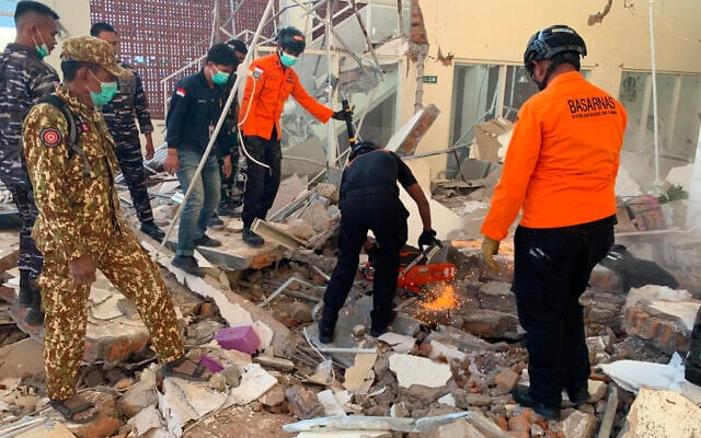 In this photo released by the Indonesian National Search and Rescue Agency (BASARNAS), rescuers attempt to clear debris at building damaged by an earthquake in Maumere, East Nusa Tenggara Province, Indonesia, August 15, 2026. (BASARNAS via AP)