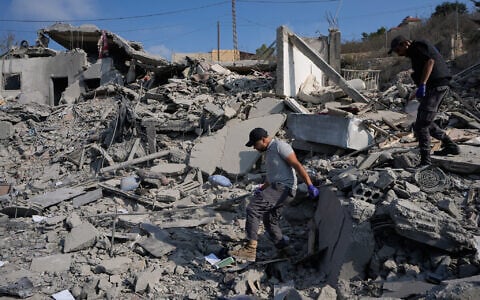 Rescue workers search for victims at a destroyed house that was hit by an Israeli airstrike in Ansar village, southern Lebanon, August 15, 2026. (AP Photo/Mohammed Zaatari)