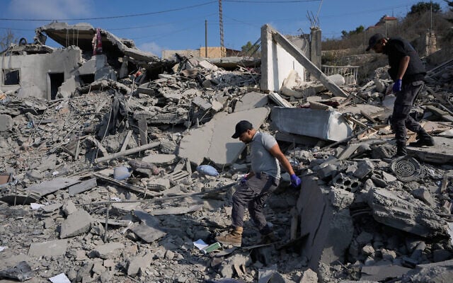 Rescue workers search for victims at a destroyed house that was hit by an Israeli airstrike in Ansar village, southern Lebanon, August 15, 2026. (AP Photo/Mohammed Zaatari)