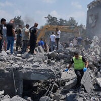 People and rescue workers gather on a destroyed house that was hit by an Israeli airstrike in Deir al-Zahrani village, southern Lebanon, August 15, 2026. (AP Photo/Mohammed Zaatari)