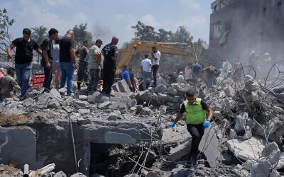 People and rescue workers gather on a destroyed house that was hit by an Israeli airstrike in Deir al-Zahrani village, southern Lebanon, August 15, 2026. (AP Photo/Mohammed Zaatari)