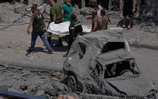 Rescue workers carry the body of a person who was killed at a house that was hit by an Israeli airstrike in Deir al-Zahrani, southern Lebanon, Saturday, August 15, 2026. (AP/Mohammed Zaatari)