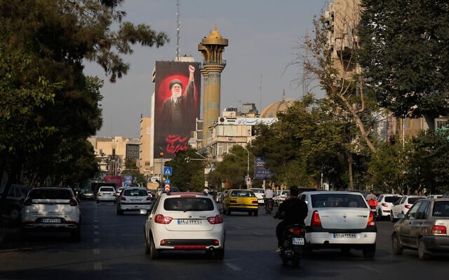 A billboard with a message that reads in Persian: 'We must rise up' and an image of the late Iranian Supreme Leader Ayatollah Ali Khamenei towers over downtown traffic in Tehran, Iran, August 15, 2026. (AP Photo/Vahid Salemi)
