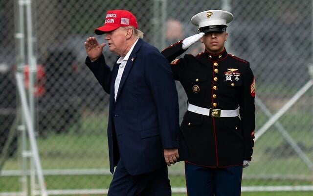 US President Donald Trump returns a salute as he walks from Marine One to his limousine upon his arrival at the Ellipse just outside of the White House, August 16, 2026, in Washington. (AP/Jose Luis Magana)