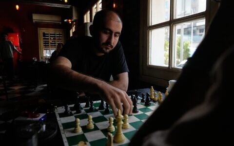 Men play chess as they spend an afternoon at a cafe in downtown Tehran, Iran, August 17, 2026. (AP/Vahid Salemi)